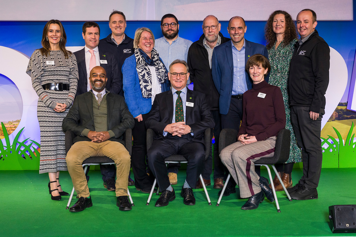 Group portrait of conference attendees and speakers on stage at OFC25