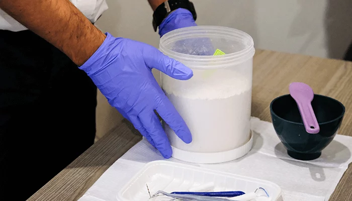 Dental prosthetist preparing denture impression materials for an aged care patient