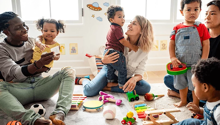 Children and caregivers playing together in a bright early learning centre playroom