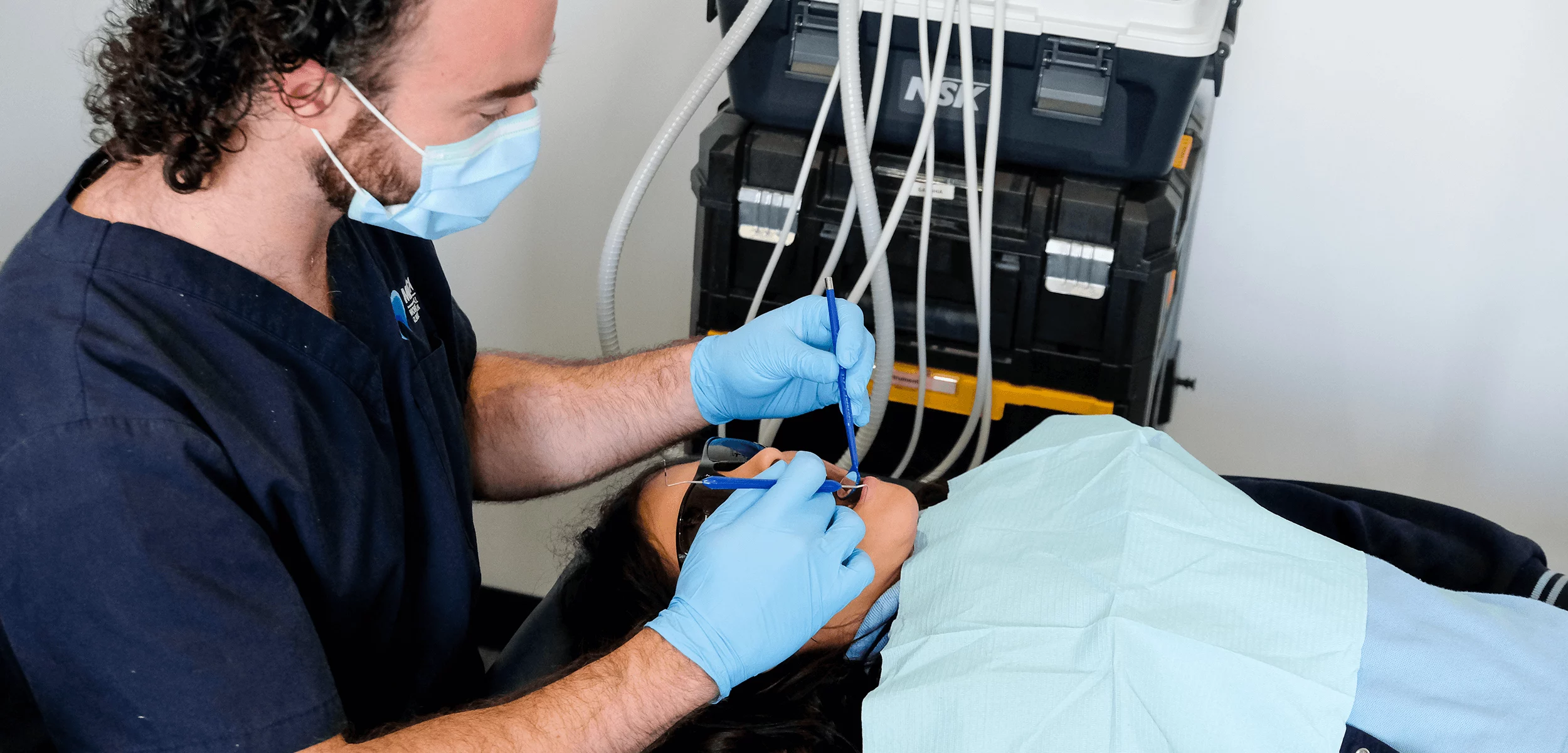 Dental professional performing a procedure on a patient in a clinical setting