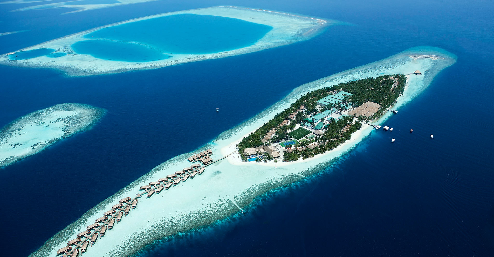 Aerial view of Vilamendhoo Island Resort surrounded by turquoise Maldives lagoon