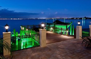 Marine-grade LED fixtures mounted on a seawall in Tampa Bay, casting warm light on the water at night