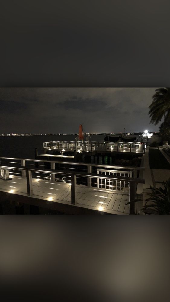 Coastal waterfront dock with nighttime LED lighting and bay view