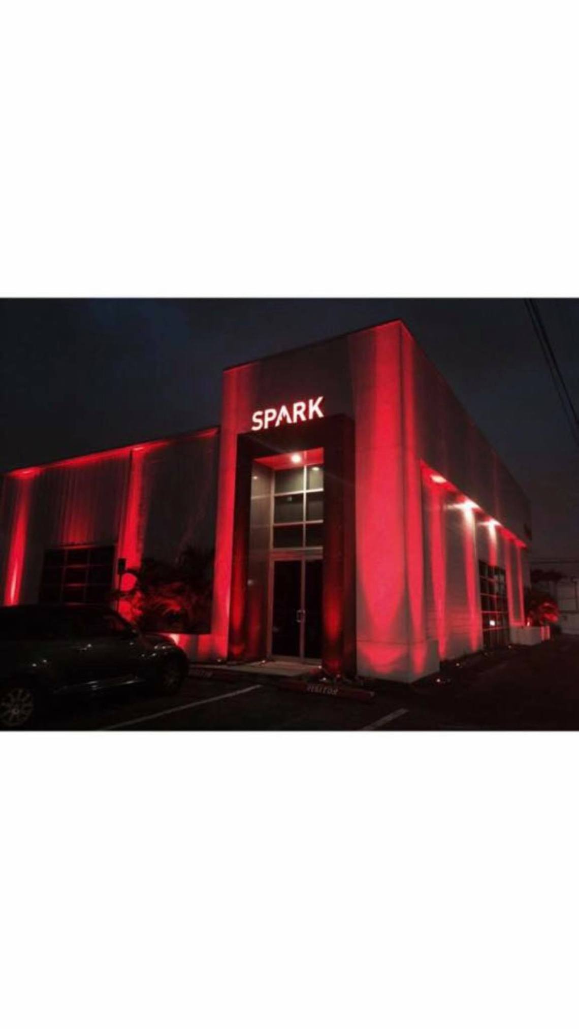 Modern commercial building with red accent architectural lighting and illuminated glass entrance