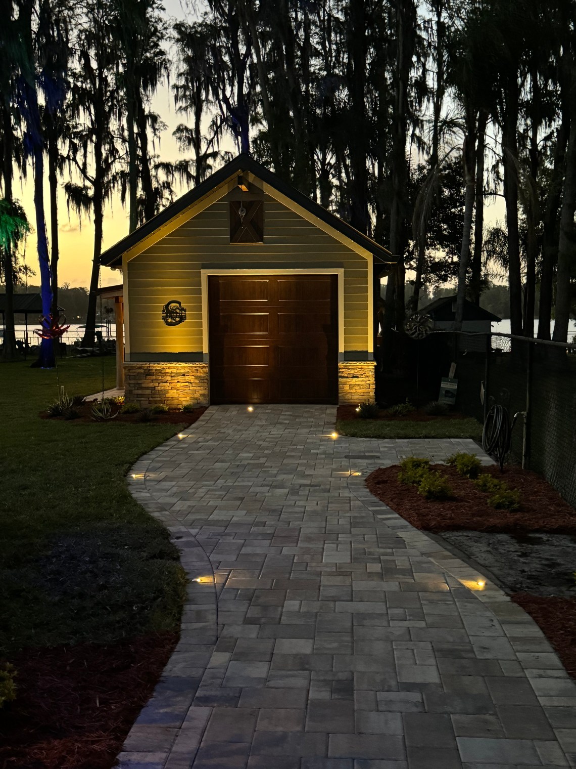 Paver driveway with in-ground path lights and landscape uplighting at dusk, residential safety lighting by LED Artistry