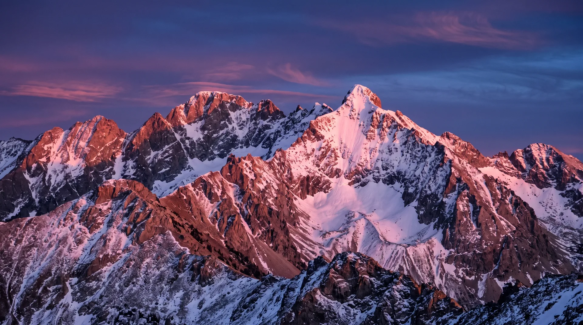 Alpenglow over Montana mountains at dusk with warm pink and orange hues
