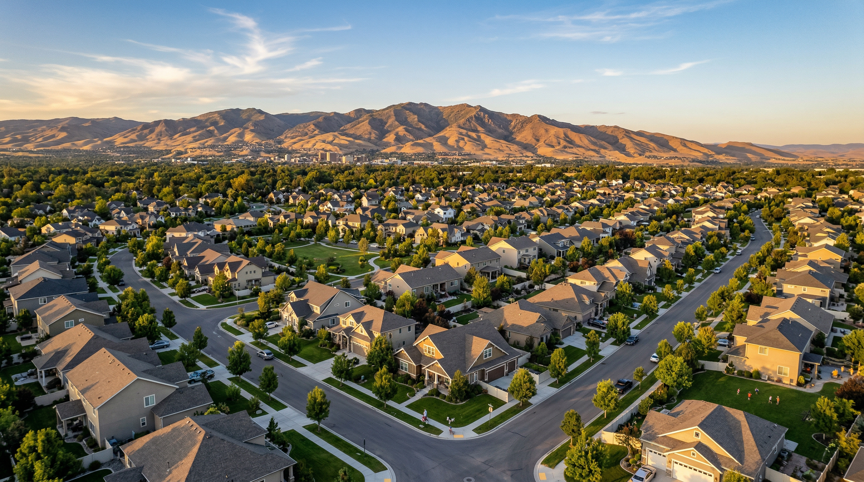 Aerial view of Treasure Valley Idaho neighborhood with mountain backdrop at golden hour