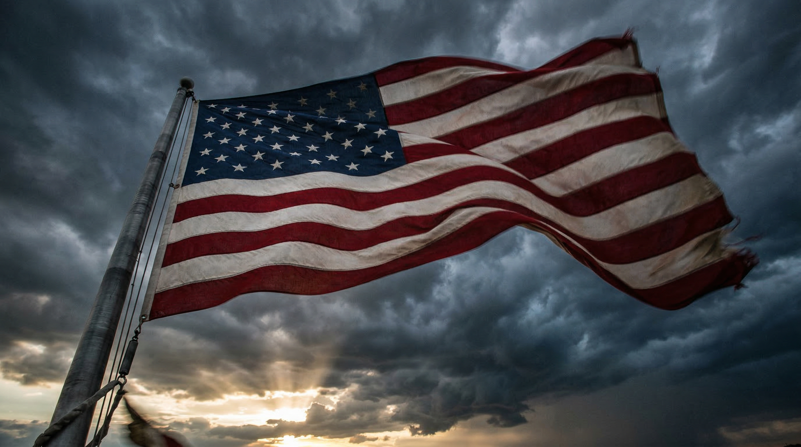 American flag waving against a stormy sky